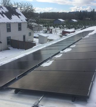 Solar panels installed on a snow-covered roof